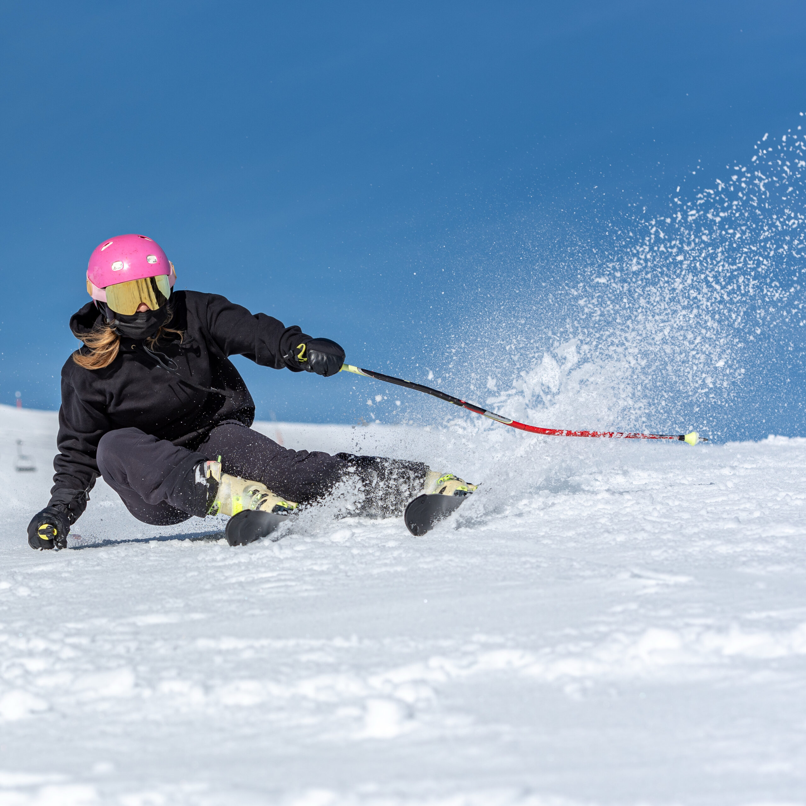 A young blonde woman skiing on a sunny day.